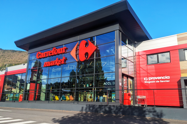 Enseigne publicitaire Carrefour Market avec lettres découpées et signalétique de façade réalisée sur un bâtiment commercial.