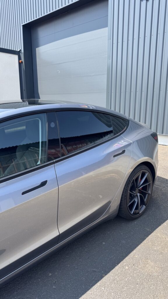 Vue latérale d'une Tesla Model 3 Performance grise après la pose de vitres teintées à Clermont-Ferrand