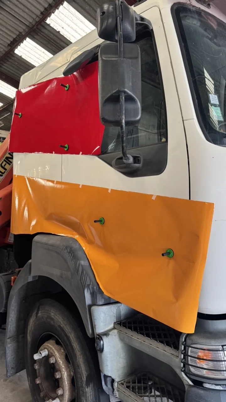 Pose du nouveau marquage adhésif rouge et orange sur le poids lourd Siegrist