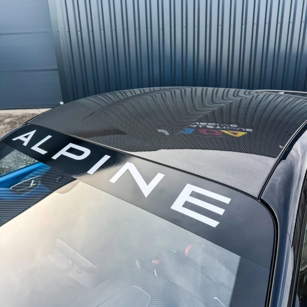 Détail du toit carbone brillant protégé par PPF brillant et bandeau de pare-brise Alpine sur une Alpine A110 R chez ADA Signalétique à Lempdes
