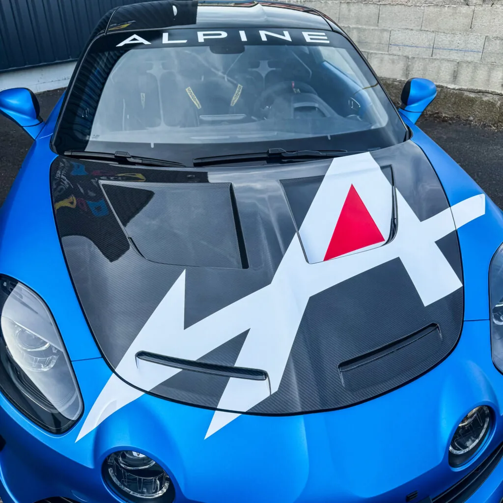 Capot carbone d'une Alpine A110 R protégé par PPF brillant avec décoration adhésive personnalisée chez ADA Signalétique près de Clermont-Ferrand