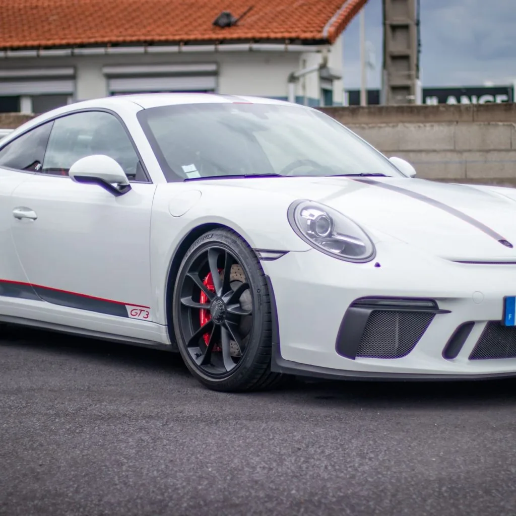 Porsche 911 GT3 blanche avec liserés rouges vue de trois quarts