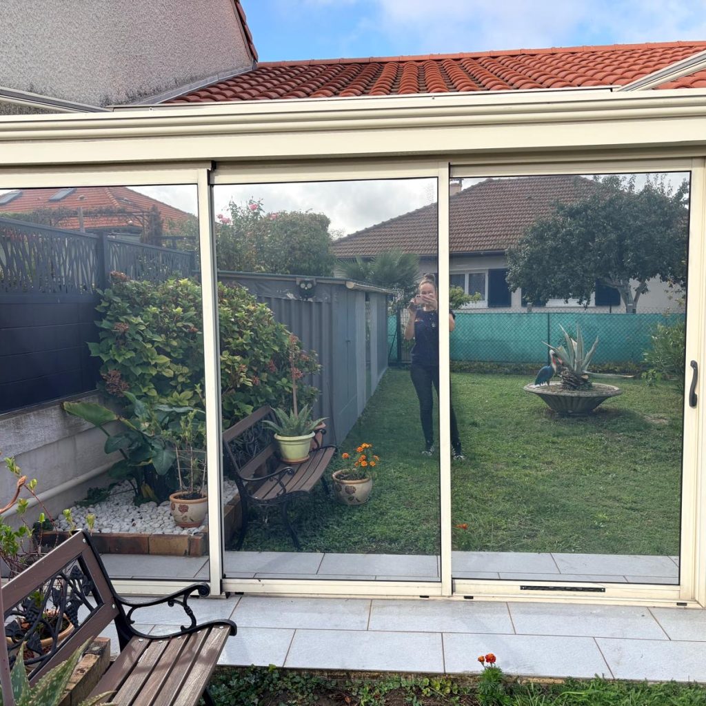 Vitrages de véranda avec reflet extérieur après pose du film solaire Chrome 285 XC